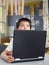 Thoughtful Boy Sitting By Laptop In Classroom