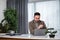 Thoughtful businessman analyzing strategy on laptop at office desk