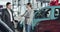 Thoughtful Caucasian woman listening to trader in car dealership. Young confident businesswoman choosing vehicle in