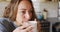 Thoughtful caucasian woman in sunny cottage kitchen drinking coffee