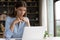 Thoughtful concentrated millennial business woman looking at computer screen.