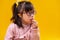 Thoughtful dark-haired child with abnormality eating snacks