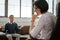 Thoughtful dark-haired female psychotherapist attentively listening to her client