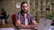 Thoughtful doubting look of black-bearded caucasian man who is looking weird at the screen of his laptop and sitting at