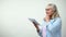 Thoughtful elderly lady using tablet, online banking app, modern technologies