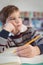 Thoughtful elementary schoolboy studing while sitting at desk