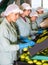 Thoughtful female employees in uniform sorting fresh apples on producing grading line