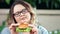 Thoughtful focused dieting fat woman doubtful looking on fresh appetizing burger close-up