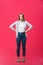 Thoughtful frowning young woman standing and thinking over pink background