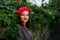 Thoughtful girl in red beret hiding in leaves.