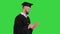 Thoughtful graduation man writing down his goals on a Green Screen, Chroma Key.