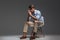 Thoughtful handsome young man sitting on chair and looking away