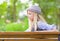 Thoughtful hipster girl sitting on bench in the park