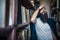 Thoughtful hipster man among bookshelves