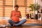 Thoughtful impregnate woman sitting on yoga carpet