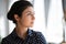 Thoughtful indian businesswoman standing indoor looks out the window