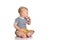 Thoughtful infant baby boy toddler is sitting on the floor with his finger at his mouth looking at copy space near him