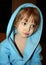 Thoughtful little girl in blue bathrobe with hood