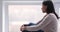 Thoughtful lonely african woman sit on sill look through window