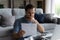 Thoughtful man checking financial documents, calculating bills, using laptop