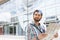 Thoughtful man looking away while holding road map against glass wall