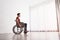 Thoughtful man sitting in wheelchair near window