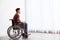 Thoughtful man sitting in wheelchair near window