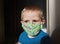 Thoughtful masked child - protection against influenza virus. Little european boy wearing tissue mask for protect