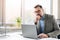 Thoughtful middle aged handsome businessman in shirt working on laptop computer in office