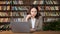 Thoughtful project manager holds pen looking into laptop