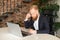 Thoughtful redhead bearded businessman staring at laptop screen