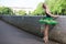 Thoughtful Relaxed Professional Caucasian Ballet Dancer in Green Tutu Dress Posing Near Stony Fence Against Sunny Sky Outdoors