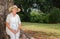 Thoughtful retired woman sitting on tree trunk