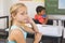 Thoughtful school girl sitting at desk with hand on face