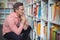 Thoughtful school teacher selecting book in library