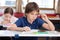 Thoughtful Schoolboy Sitting At Desk