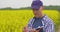 Thoughtful Scientist Writing In Clipboard At Rapeseed Field