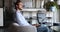 Thoughtful serious businessman using laptop sitting on chair in office