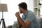 Thoughtful serious man sitting on sofa at home, lost in thoughts