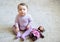 Thoughtful and serious nice baby girl sitting on the floor