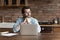 Thoughtful serious remote employee working form home, sitting at table