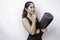 Thoughtful sporty Asian woman wearing sportswear is holding yoga mat on isolated white background