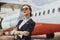 Thoughtful stewardess on runway near airplane jet