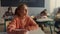 Thoughtful student sitting at school desk. Smiling girl answering questions