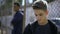 Thoughtful teen boys leaning on metal fence, abandoned, upset with future