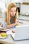 Thoughtful teenager girl studying in kitchen