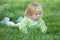 Thoughtful toddler is crawling in the green grass