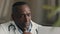 Thoughtful wise experienced mature 50s man african american doctor medical professor general practitioner sit at
