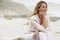 Thoughtful Woman Looking Away While Sitting On Rock At Beach