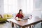 Thoughtful woman looking at laptop. Pensive focused female freelancer in glasses sitting at home